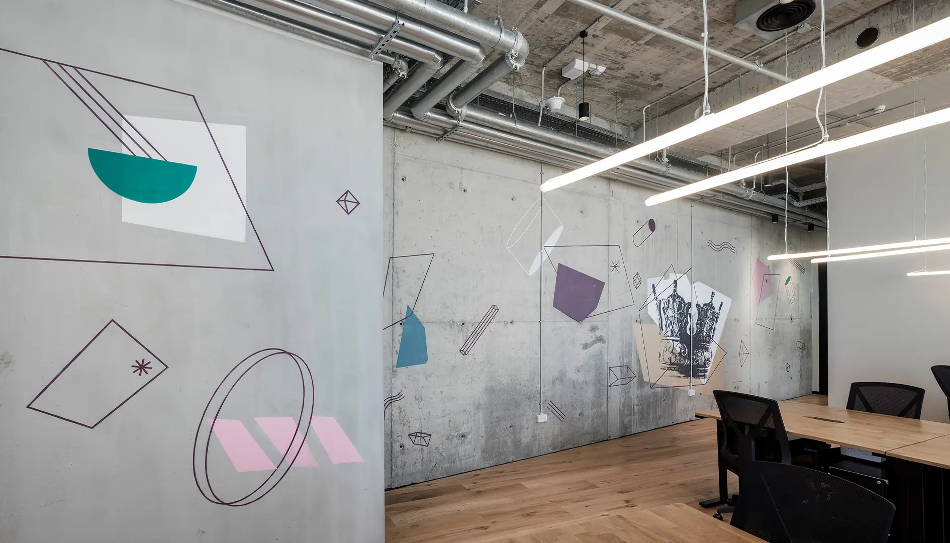 Concrete wall — geometric line work drawn directly onto the raw surface, punctuated by flat colour shapes.